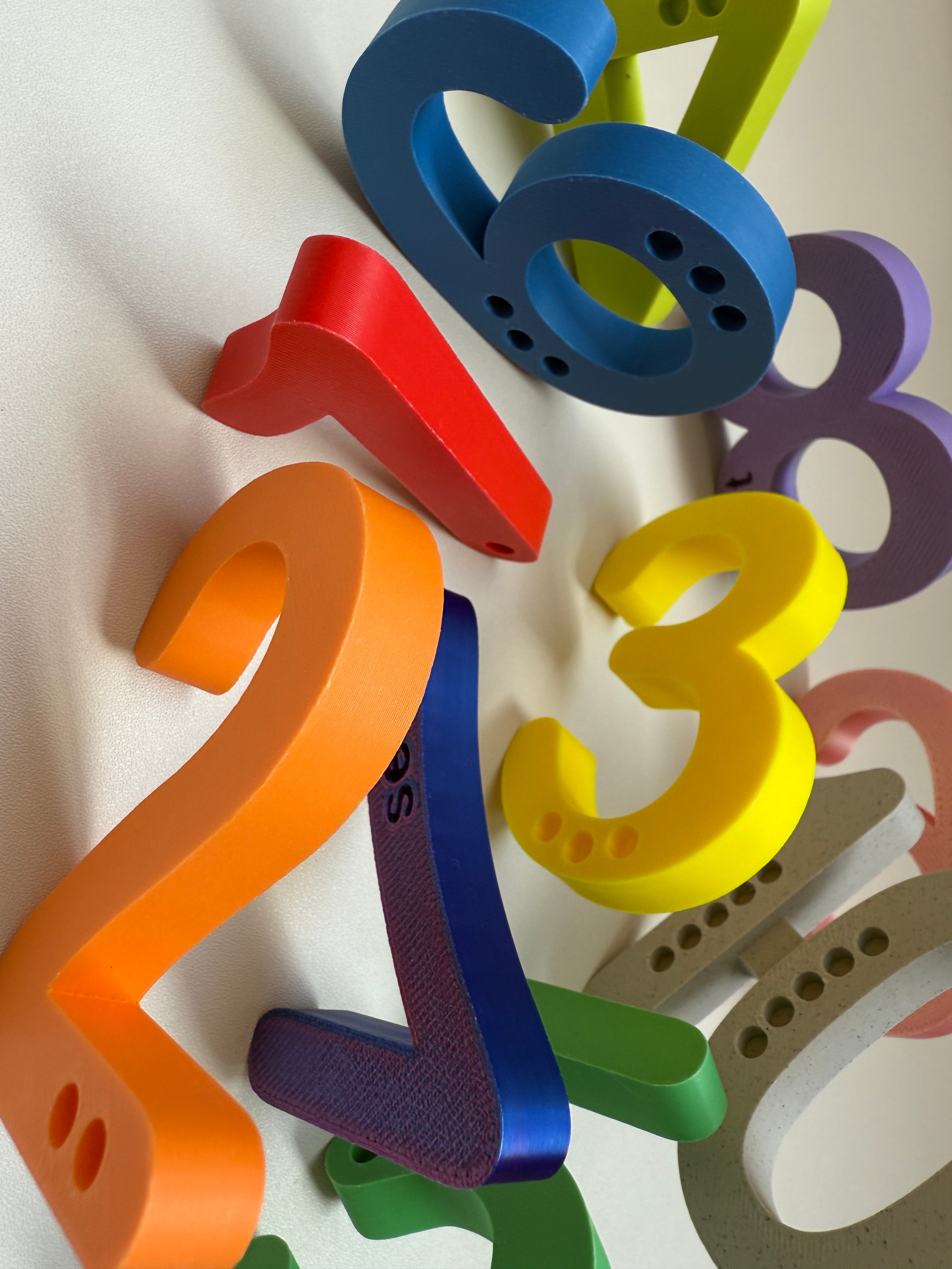 Colorful 3D-printed letters on a white background