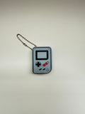 Keychain designed like a retro video game console on a light gray background