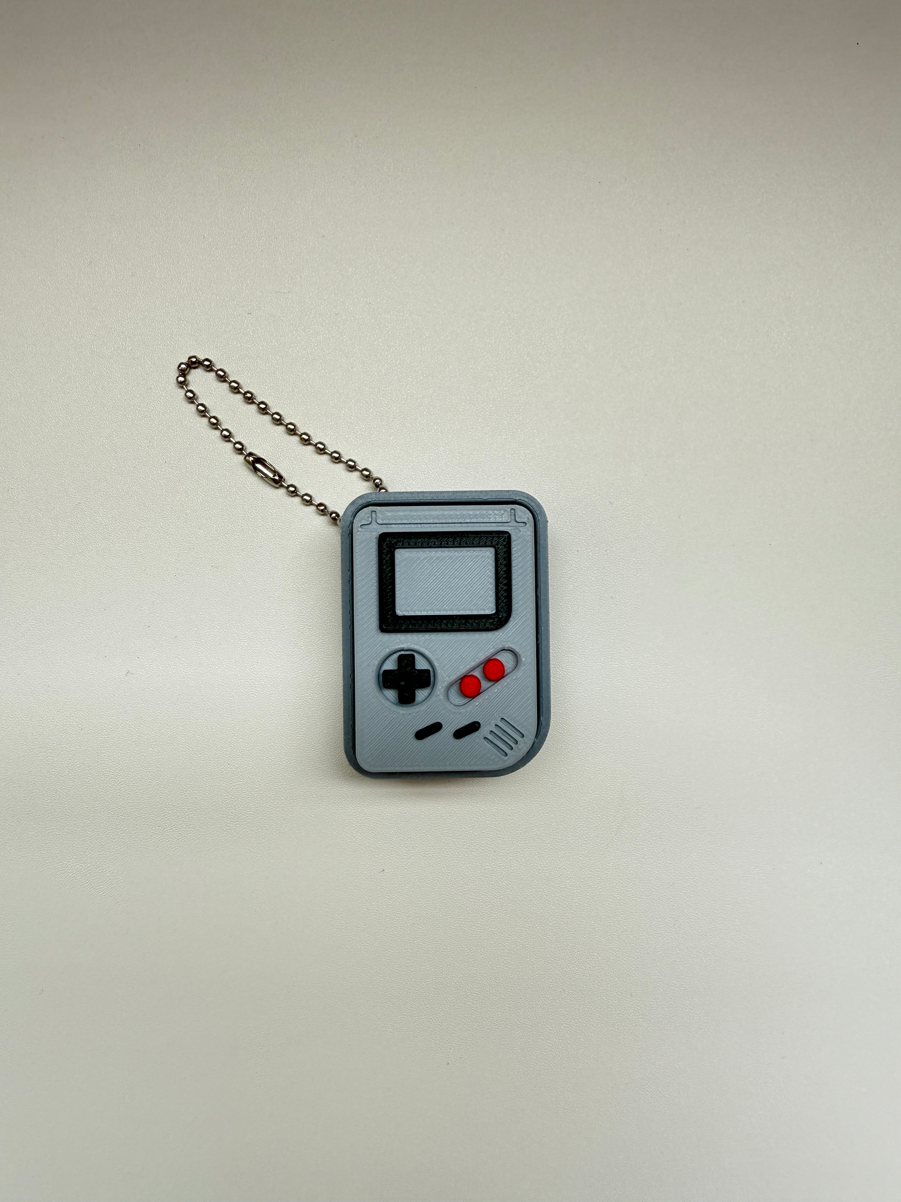 Keychain designed like a retro video game console on a light gray background